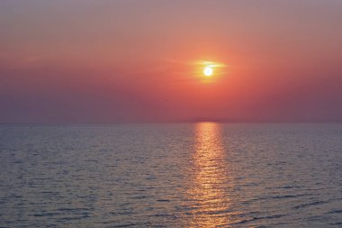 Denize giden güneş yolu. Gün batımı ya da denizde gün doğumu. Açık ufuk.