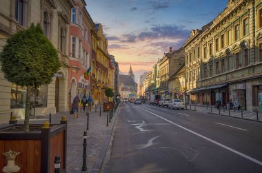 Brasov, Romanya: 05 Ocak 2019: Gün batımında Brasov 'un güzel sokakları. Brasov caddelerinin şehir manzarası Siyah Kilise ile arka planda