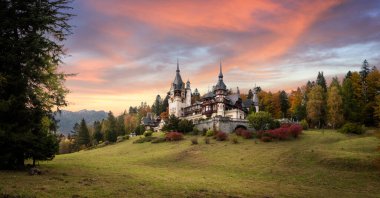 Romanya 'nın Peles Kalesi Panoraması. Günbatımında Avrupa 'daki Karpat Dağları' nın Sinaia 'daki güzel kraliyet kalesi ve süs bahçesi. Romanya Kraliyet Ailesi 'nin Eski Evi. 