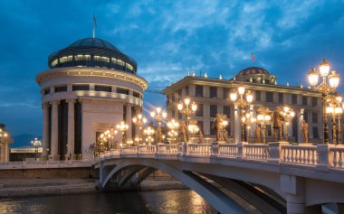 Skopje, Macedonia. The Art bridge leading towards the Ministry of Foreign Affairs and the Financial Police is decorated by many statues related to history of Macedonia. Night view clipart