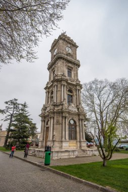 İSTANBUL, TURKEY - 7 Nisan 2019: Saat Kulesi (Saat Kulesi), şimdi büyük bir ulusal ve turistik kent simgesi olan Nihai Osmanlı Sultanlarının evi olan muhteşem Dolmabahce Sarayı 'nın girişinde. 