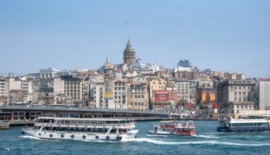 İstanbul, Türkiye - 16 Nisan 2019: Ünlü Galata Kulesi 'nin bulunduğu Galata Bölgesi Sahnesi ve Altın Boynuz üzerinde tekne ve gemiler. Galata Kulesi şehrin en önemli turistik yerlerinden biridir.. 