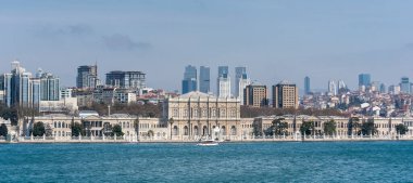 İstanbul, Türkiye - 26 Nisan 2019: Son Osmanlı Sultanlarına ev sahipliği yapan muhteşem Dolmabahce Sarayı manzarası. Önünde gemi, arkasında gökdelenler. Boğazdan Görünüm
