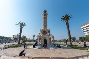 İzmir, Türkiye - 01 Kasım 2019: Eski saat kulesiyle Konak Meydanı sokak manzarası. 1901 yılında inşa edilmiş ve İzmir 'in resmi sembolü olarak kabul edilmiştir.. 