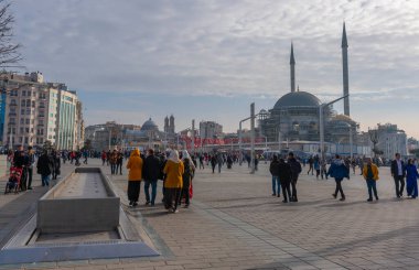 İstanbul, Türkiye - 26 Nisan 2019: Arka planda inşaat halindeki Taksim Meydanı 'nda insanlar yürüyor.