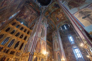 SERGIYEV POSAD, RUSSIA - 19.02.2020: The Dormition Church Trinity Lavra of St. Sergius, Assumption Cathedral 'in içi. Eski simgelerle azizleri ve simgeleri tasvir eden freskleri olan duvarlar.