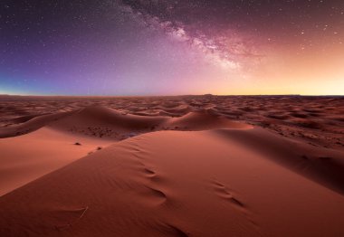 Merzouga, Fas, Afrika yakınlarındaki Sahra Çölü 'ndeki kum tepeleri üzerinde inanılmaz samanyolu. Yıldızlarla dolu çarpıcı gökyüzü ve yıldızlı gökyüzünün altında gece olan güzel kum manzarası. Gün batımından sonra