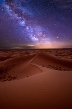 Merzouga, Fas, Afrika yakınlarındaki Sahra Çölü 'ndeki kum tepeleri üzerinde inanılmaz samanyolu. Yıldızlarla dolu çarpıcı gökyüzü ve yıldızlı gökyüzünün altında gece olan güzel kum manzarası. Gün batımından sonra