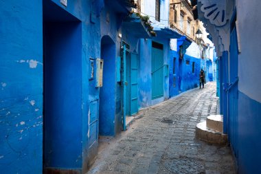 Mavi şehrin güzel manzarası CheFCHAOUEN, Medina 'daki MoroCCO. Geleneksel Fas mimari detayları ve boyalı evler. Kapısı olan bir sokak ve kemerli parlak mavi duvarlar