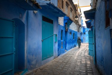 Mavi şehrin güzel manzarası CheFCHAOUEN, Medina 'daki MoroCCO. Geleneksel Fas mimari detayları ve boyalı evler. Kapısı olan bir sokak ve kemerli parlak mavi duvarlar