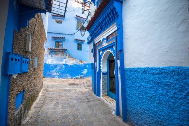 Mavi şehrin güzel manzarası CheFCHAOUEN, Medina 'daki MoroCCO. Geleneksel Fas mimari detayları ve boyalı evler. Kapısı olan bir sokak ve kemerli parlak mavi duvarlar