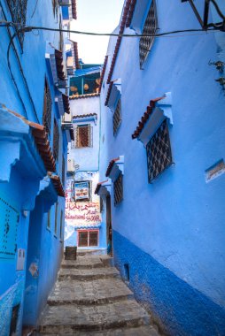 Mavi şehrin güzel manzarası CheFCHAOUEN, Medina 'daki MoroCCO. Geleneksel Fas mimari detayları ve boyalı evler. Kapısı olan bir sokak ve kemerli parlak mavi duvarlar