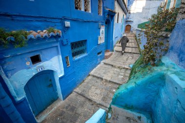 Mavi şehrin güzel manzarası CheFCHAOUEN, Medina 'daki MoroCCO. Geleneksel Fas mimari detayları ve boyalı evler. Kapısı olan bir sokak ve kemerli parlak mavi duvarlar