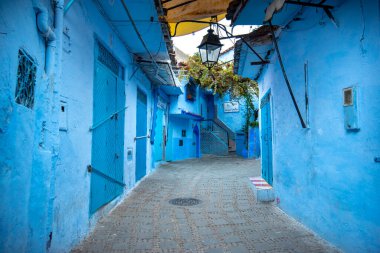 Mavi şehrin güzel manzarası CheFCHAOUEN, Medina 'daki MoroCCO. Geleneksel Fas mimari detayları ve boyalı evler. Kapısı olan bir sokak ve kemerli parlak mavi duvarlar