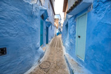 Mavi şehrin güzel manzarası CheFCHAOUEN, Medina 'daki MoroCCO. Geleneksel Fas mimari detayları ve boyalı evler. Kapısı olan bir sokak ve kemerli parlak mavi duvarlar