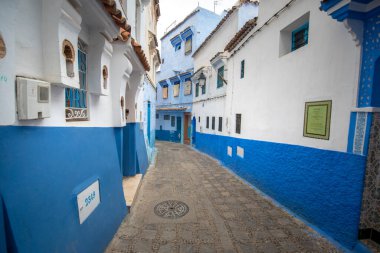Mavi şehrin güzel manzarası CheFCHAOUEN, Medina 'daki MoroCCO. Geleneksel Fas mimari detayları ve boyalı evler. Kapısı olan bir sokak ve kemerli parlak mavi duvarlar