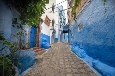 Mavi şehrin güzel manzarası CheFCHAOUEN, Medina 'daki MoroCCO. Geleneksel Fas mimari detayları ve boyalı evler. Kapısı olan bir sokak ve kemerli parlak mavi duvarlar