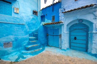 Mavi şehrin güzel manzarası CheFCHAOUEN, Medina 'daki MoroCCO. Geleneksel Fas mimari detayları ve boyalı evler. Kapısı olan bir sokak ve kemerli parlak mavi duvarlar