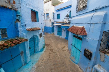 Mavi şehrin güzel manzarası CheFCHAOUEN, Medina 'daki MoroCCO. Geleneksel Fas mimari detayları ve boyalı evler. Kapısı olan bir sokak ve kemerli parlak mavi duvarlar
