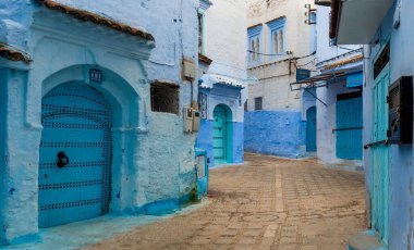 Mavi şehrin güzel manzarası CheFCHAOUEN, Medina 'daki MoroCCO. Geleneksel Fas mimari detayları ve boyalı evler. Kapısı olan bir sokak ve kemerli parlak mavi duvarlar