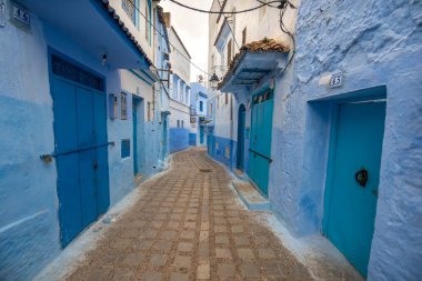 Mavi şehrin güzel manzarası CheFCHAOUEN, Medina 'daki MoroCCO. Geleneksel Fas mimari detayları ve boyalı evler. Kapısı olan bir sokak ve kemerli parlak mavi duvarlar