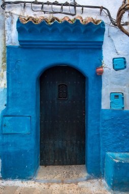 Tipik, eski, karmaşık bir şekilde oyulmuş, çivili, Faslı kapı ve çerçeve ve CheFCHAOUEN, Fas 'taki eski ev. Medine 'deki mavi şehrin güzel manzarası. boyanmış evler
