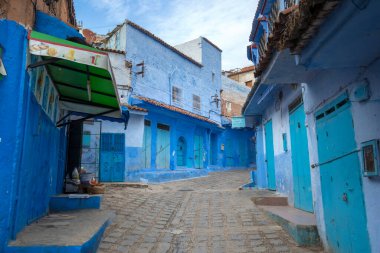Mavi şehrin güzel manzarası CheFCHAOUEN, Medina 'daki MoroCCO. Geleneksel Fas mimari detayları ve boyalı evler. Kapısı olan bir sokak ve kemerli parlak mavi duvarlar