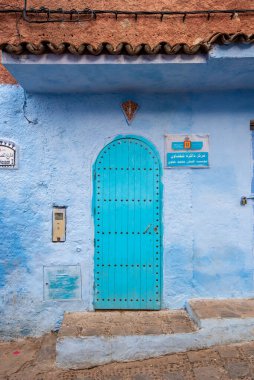 Tipik, eski, karmaşık bir şekilde oyulmuş, çivili, Faslı kapı ve çerçeve ve CheFCHAOUEN, Fas 'taki eski ev. Medine 'deki mavi şehrin güzel manzarası. boyanmış evler