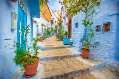 Mavi şehrin güzel manzarası CheFCHAOUEN, Medina 'daki MoroCCO. Geleneksel Fas mimari detayları ve boyalı evler. Kapısı olan bir sokak ve kemerli parlak mavi duvarlar
