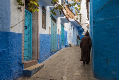 Mavi şehrin güzel manzarası CheFCHAOUEN, Medina 'daki MoroCCO. Geleneksel Fas mimari detayları ve boyalı evler. Kapısı olan bir sokak ve kemerli parlak mavi duvarlar