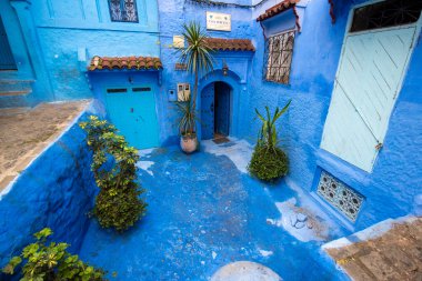 Mavi şehrin güzel manzarası CheFCHAOUEN, Medina 'daki MoroCCO. Geleneksel Fas mimari detayları ve boyalı evler. Kapısı olan bir sokak ve kemerli parlak mavi duvarlar