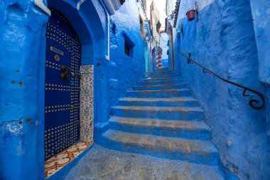 Mavi şehrin güzel manzarası CheFCHAOUEN, Medina 'daki MoroCCO. Geleneksel Fas mimari detayları ve boyalı evler. Kapısı olan bir sokak ve kemerli parlak mavi duvarlar