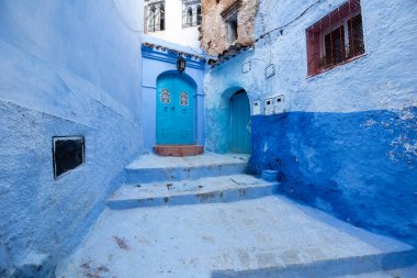 Mavi şehrin güzel manzarası CheFCHAOUEN, Medina 'daki MoroCCO. Geleneksel Fas mimari detayları ve boyalı evler. Kapısı olan bir sokak ve kemerli parlak mavi duvarlar