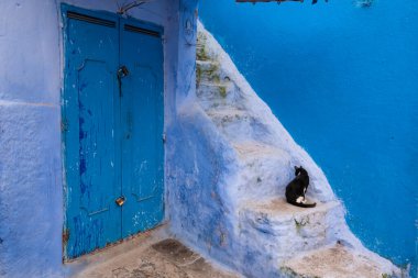 Tipik, eski, karmaşık bir şekilde oyulmuş, çivili, Faslı kapı ve çerçeve ve CheFCHAOUEN, Fas 'taki eski ev. Medine 'deki mavi şehrin güzel manzarası. boyanmış evler