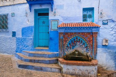 Mavi şehrin güzel manzarası CheFCHAOUEN, Medina 'daki MoroCCO. Geleneksel Fas mimari detayları ve boyalı evler. Kapısı olan bir sokak ve kemerli parlak mavi duvarlar