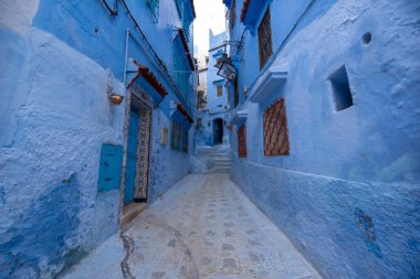 Mavi şehrin güzel manzarası CheFCHAOUEN, Medina 'daki MoroCCO. Geleneksel Fas mimari detayları ve boyalı evler. Kapısı olan bir sokak ve kemerli parlak mavi duvarlar