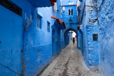 Mavi şehrin güzel manzarası CheFCHAOUEN, Medina 'daki MoroCCO. Geleneksel Fas mimari detayları ve boyalı evler. Kapısı olan bir sokak ve kemerli parlak mavi duvarlar