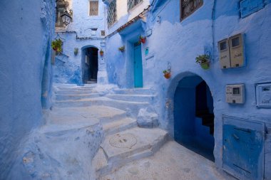 Mavi şehrin güzel manzarası CheFCHAOUEN, Medina 'daki MoroCCO. Geleneksel Fas mimari detayları ve boyalı evler. Kapısı olan bir sokak ve kemerli parlak mavi duvarlar