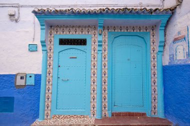 Tipik, eski, karmaşık bir şekilde oyulmuş, çivili, Faslı kapı ve çerçeve ve CheFCHAOUEN, Fas 'taki eski ev. Medine 'deki mavi şehrin güzel manzarası. boyanmış evler