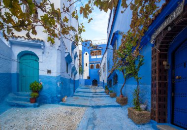 Mavi şehrin güzel manzarası CheFCHAOUEN, Medina 'daki MoroCCO. Geleneksel Fas mimari detayları ve boyalı evler. Kapısı olan bir sokak ve kemerli parlak mavi duvarlar