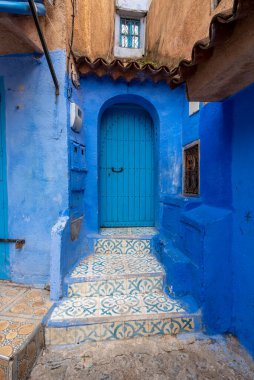 Tipik, eski, karmaşık bir şekilde oyulmuş, çivili, Faslı kapı ve çerçeve ve CheFCHAOUEN, Fas 'taki eski ev. Medine 'deki mavi şehrin güzel manzarası. boyanmış evler