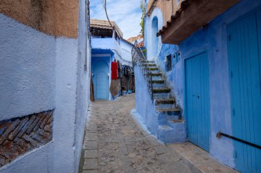 Mavi şehrin güzel manzarası CheFCHAOUEN, Medina 'daki MoroCCO. Geleneksel Fas mimari detayları ve boyalı evler. Kapısı olan bir sokak ve kemerli parlak mavi duvarlar