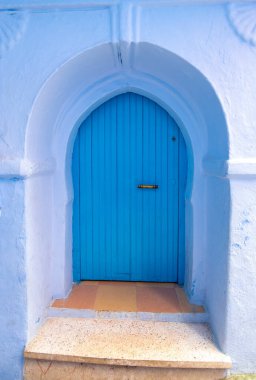 Tipik, eski, karmaşık bir şekilde oyulmuş, çivili, Faslı kapı ve çerçeve ve CheFCHAOUEN, Fas 'taki eski ev. Medine 'deki mavi şehrin güzel manzarası. boyanmış evler