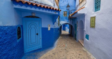 Mavi şehrin güzel manzarası CheFCHAOUEN, Medina 'daki MoroCCO. Geleneksel Fas mimari detayları ve boyalı evler. Kapısı olan bir sokak ve kemerli parlak mavi duvarlar