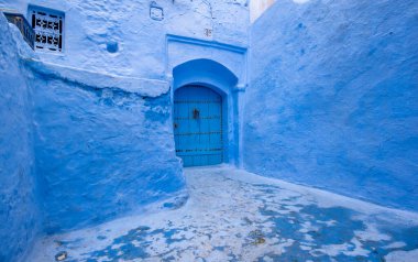 Mavi şehrin güzel manzarası CheFCHAOUEN, Medina 'daki MoroCCO. Geleneksel Fas mimari detayları ve boyalı evler. Kapısı olan bir sokak ve kemerli parlak mavi duvarlar
