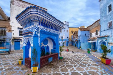 CHEFCHAOUEN, FOCCO - 27 Mart 2019: Medine 'deki mavi şehrin güzel manzarası. Geleneksel Fas mimari detayları ve boyalı evler. El Haouta Meydanı 'ndaki Çeşme