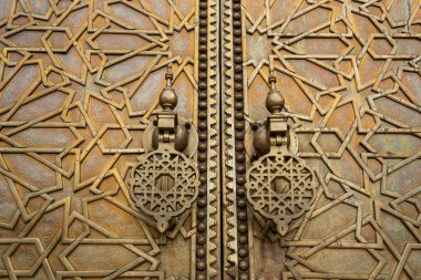 Fes, Fas 'taki Royal Palace' ın (Fez) girişindeki süslü altın metalden yapılmış Bab Majzen kapısı hakkında güzel detaylar. Dar al-Makhzen 'in süslemeli geometrik deseni ve sapları veya tokmakları