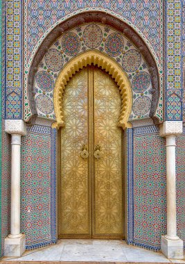 Fes, Fas 'taki Royal Palace' ın (Fez) girişindeki süslü altın metalden yapılmış Bab Majzen kapısı hakkında güzel detaylar. Dar al-Makhzen 'in süslemeli geometrik deseni ve sapları veya tokmakları