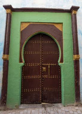 Rabat, Fas. Geleneksel Fas tarzı bir antik ahşap giriş kapısı tasarımı. Eski Medine 'de. Tipik, eski, karmaşık bir şekilde oyulmuş, çivili, Fas riad kapısı.