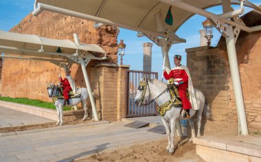 RABAT, MOROCCO - 20 Aralık 2019: Hasan Kulesi 'nin önündeki girişi koruyan at üzerindeki kraliyet muhafızları ve Muhammed V. Mausoleum' un mozolesinde rahmetli Kral II. Hasan ve Prens Abdullah II.